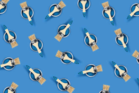 Renovation concept. Pattern with blue background with color paint jars and brushes. Flat lay, top view.の写真素材