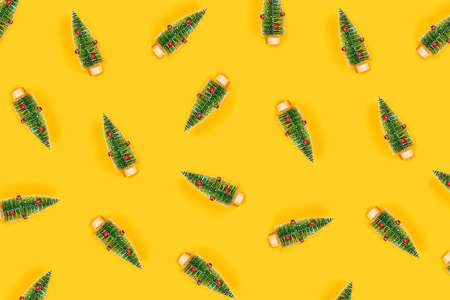 Christmas and New year yellow decorative pattern with green randomly arranged christmas trees. Flat...