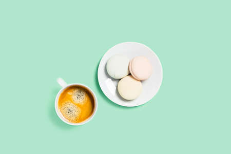 Food-drink mint concept. Tasty marshmallows wrapped in saucer with cup of hot coffee. Flat lay, top view, copy space.の写真素材