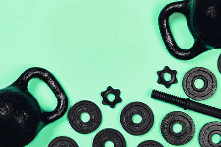 Sports flat-lay. Kettlebell and dumbbell on mint background. Flat lay, top view, copy space.の写真素材