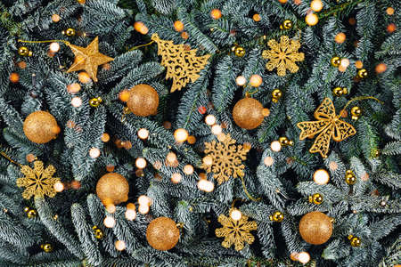 New year and Christmas concept. Christmas branches decorated with gold balls and toys. Flat lay, top...