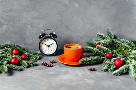 Christmas and New year composition with orange cup of coffee surrounded by fir brunches with red...
