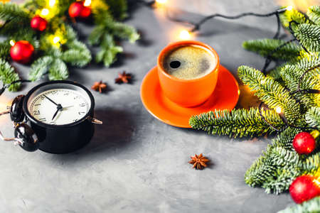 Christmas composition - tasty coffee in orange cup on gray background surrounded by red Christmas...