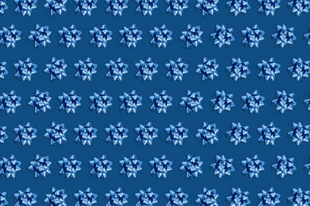 Christmas and new year pattern. Celebration picture. Pink background with blue bright bows. Flat lay, top view, copy space.の写真素材