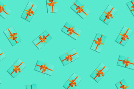 Pattern with mint gifts and orange ribbon located on green background.の写真素材