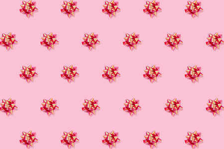 Greeting card. Pattern with pink background and red bright bows. Flat lay, top view.の写真素材