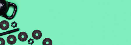 Sports web-banner. Kettlebells and dumbbells on mint green background. Flat lay, top view, copy space.の写真素材