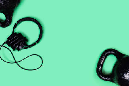 Sports picture. Kettlebells and dumbbells on mint green background. Flat lay, top view, copy space.の写真素材