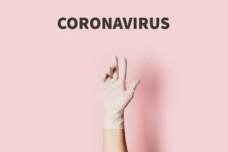 Hand in medical glove with text on pink background. Photo on the theme of coronavirus 2019-ncov in China. Flat lay, top view.の写真素材