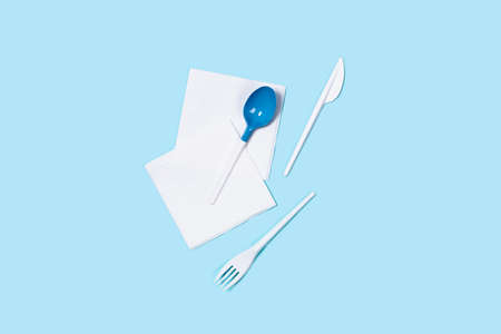 Picture of white plastic spoons on blue background. Flat lay, top view, copy space.の写真素材