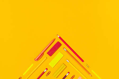 School and university supplies in a corner shape on yellow background. Flat lay, top view, copy space.の写真素材