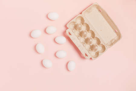 Happy Easter. White eggs located near paper packaging on pink background. Flat lay, top view, copy space.の写真素材