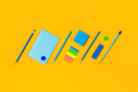 Back to school picture. Blue accessories on a yellow background. Central composition.の写真素材