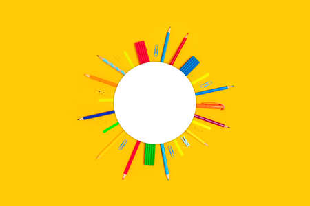 School and university supplies on yellow background with white corcle for the text. Flat lay, top view, copy space.の写真素材