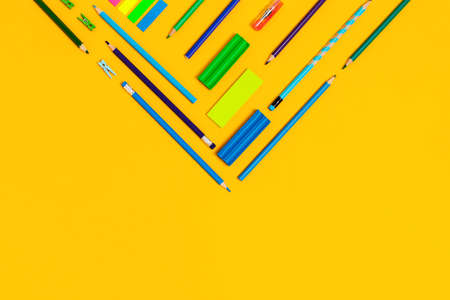 School and university supplies on yellow background in a shape of corner. Flat lay, top view, copy...
