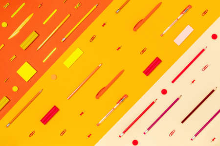 School and university supplies on yellow tricolor background. Flat lay, top view, copy space.