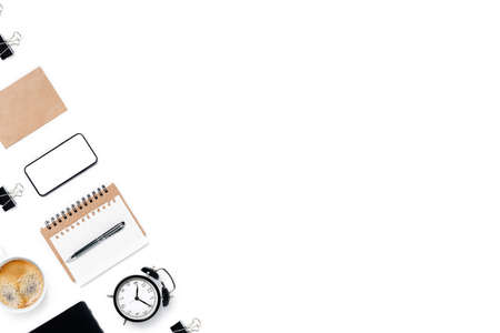 Modern workspace with smartphone, notepad, pen and alarm clock. Flat lay, top view, copy space.