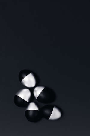 Five black and silver Easter eggs on dark grey vertical background. Flat lay, top view, copy space.の写真素材