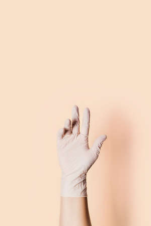 Hand in medical glove with place for text on yellow background.の写真素材
