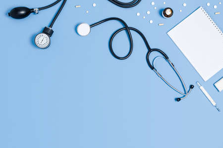 Top view at the doctor's workplace. A stethoscope, syringes, pills on blue background.の写真素材