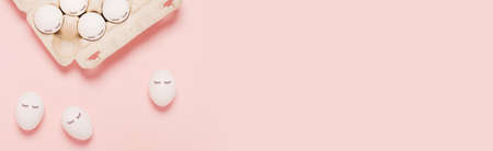 Festive Easter pink web banner with white eggs and eyes drawn on them. The inscription is a happy...