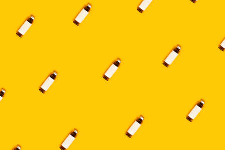 Ecological accessories for body care with glass bottles on yellow background.