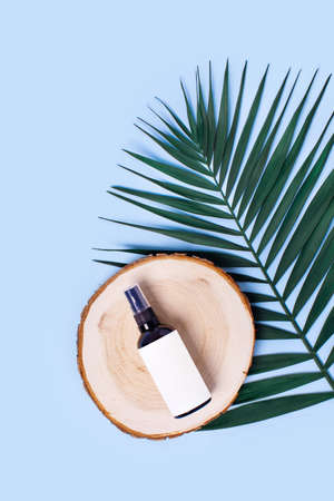 Advertising image. Glass spray bottle on a blue background surrounded by lavender.の写真素材