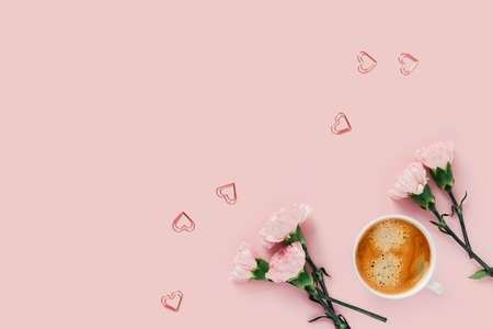 Morning cup of coffee and flowers with hearts on pink background.の写真素材