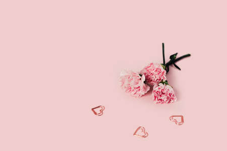 Roses on a pink background with three metal hearts.の写真素材
