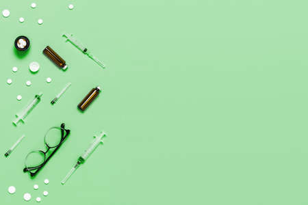 Medical neo mint green background with different accessories: stethoscope, thermometer, syringe and...