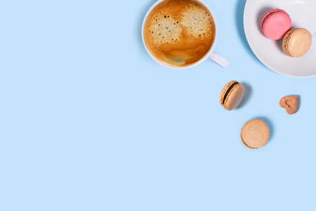 Blue background with macaroons and cup of coffee. Top view with space for your text.の写真素材