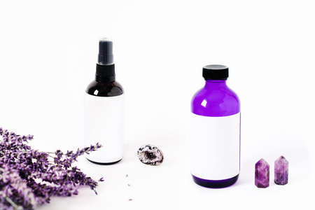 Glass spray bottles on white background surrounded by lavender bouquet and the crystal of quartz. Energy of stones for your home.の写真素材