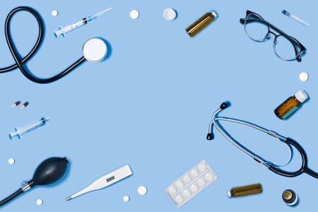 Medical blue background with different accessories: stethoscope, syringe and tablets.の写真素材