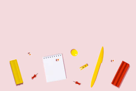 Back to school flat lay with yellow and red plasticine, paper clips.の写真素材