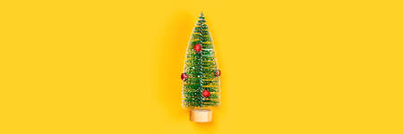 Christmas and New year yellow decorative background with one christmas tree. Flat lay, top view,...
