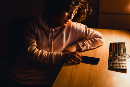 Young woman with curly hair sits on the internet instead of working.の写真素材