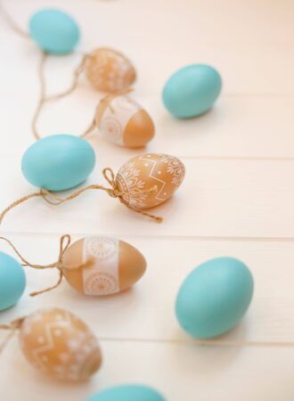 beautiful blue and beige easter eggs on wooden white background.の写真素材