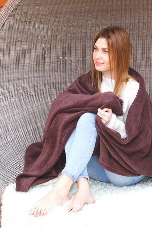 beautiful woman wrapped in a cozy brown plaidの写真素材