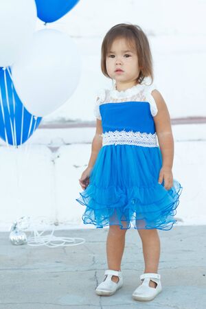pretty baby in blue dresses on a summer walkの写真素材