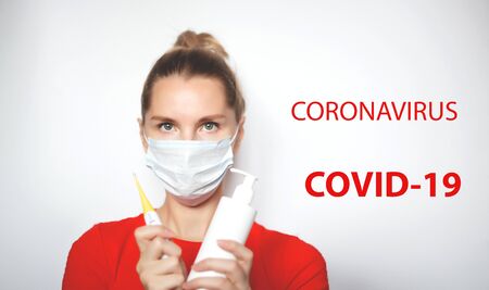 woman in red t-shirt in a medical mask whith a disinfector and a thermometer. inscription...