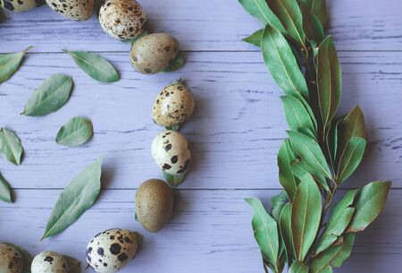 circle of quail eggs and leaves. happy easter. flat lay