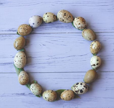circle of quail eggs on a gray wooden background. happy easter. flat layの写真素材