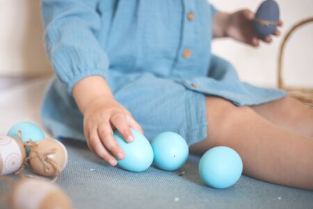 blue-eyed blonde girl with a basket of Easter eggs in a vintage dress.の写真素材