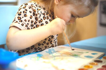 little girl at home paints. home schooling, distance learning.の写真素材