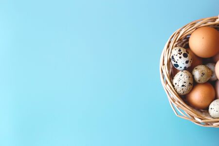wicker basket with quail and compartment eggs on a gray background. happy easter.の写真素材
