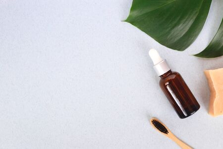 The concept of zero waste. bamboo toothbrush, solid shampoo and serum on a manstera sheet. flat layの写真素材
