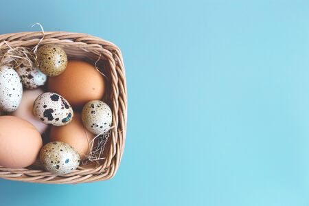 wicker basket with quail and compartment eggs on a gray background. happy easter.の写真素材