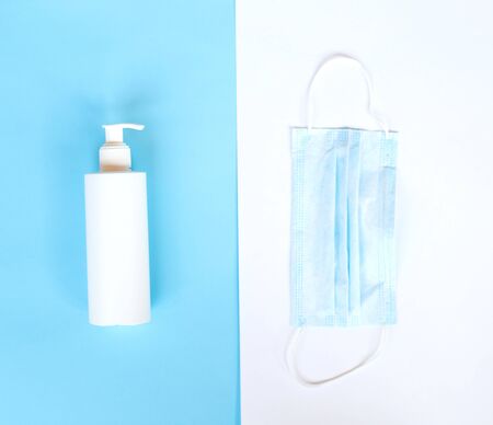medical mask and disinfector on a blue and white background. flat lay.の写真素材