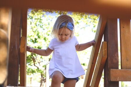 little blue-eyed girl plays in the playground.の写真素材