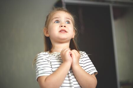 Little cute blonde blue-eyed girl is dreaming.の写真素材